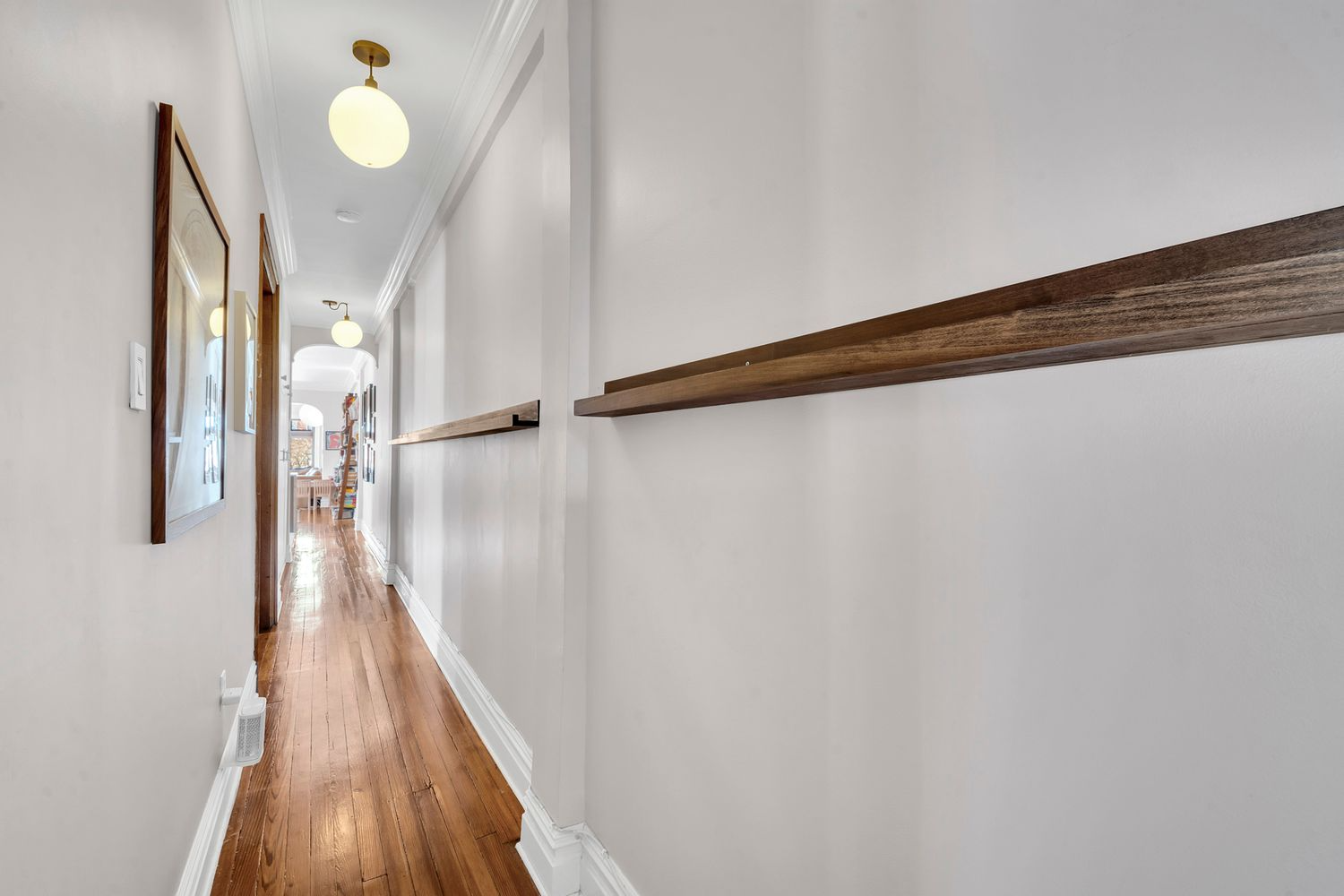 hall with wood floor, wood picture shelves
