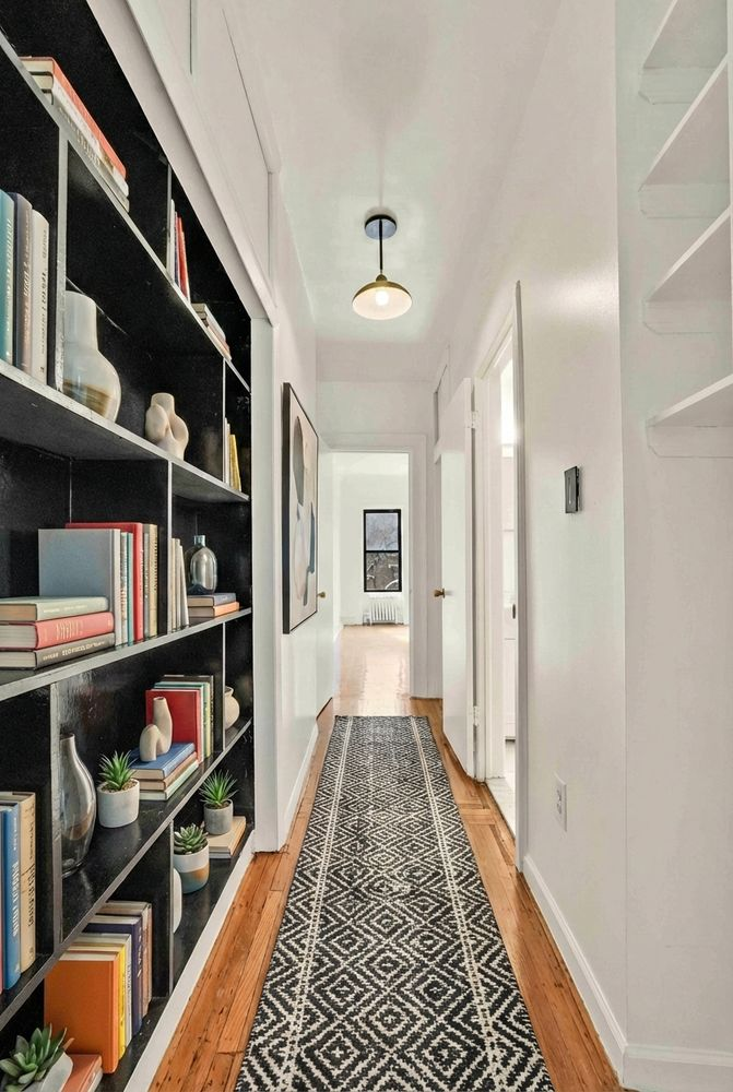hallway with bookcases and a runner