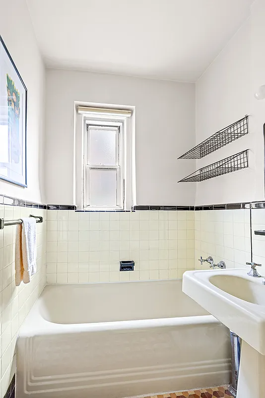a bathroom with vintage white fixtures and tile