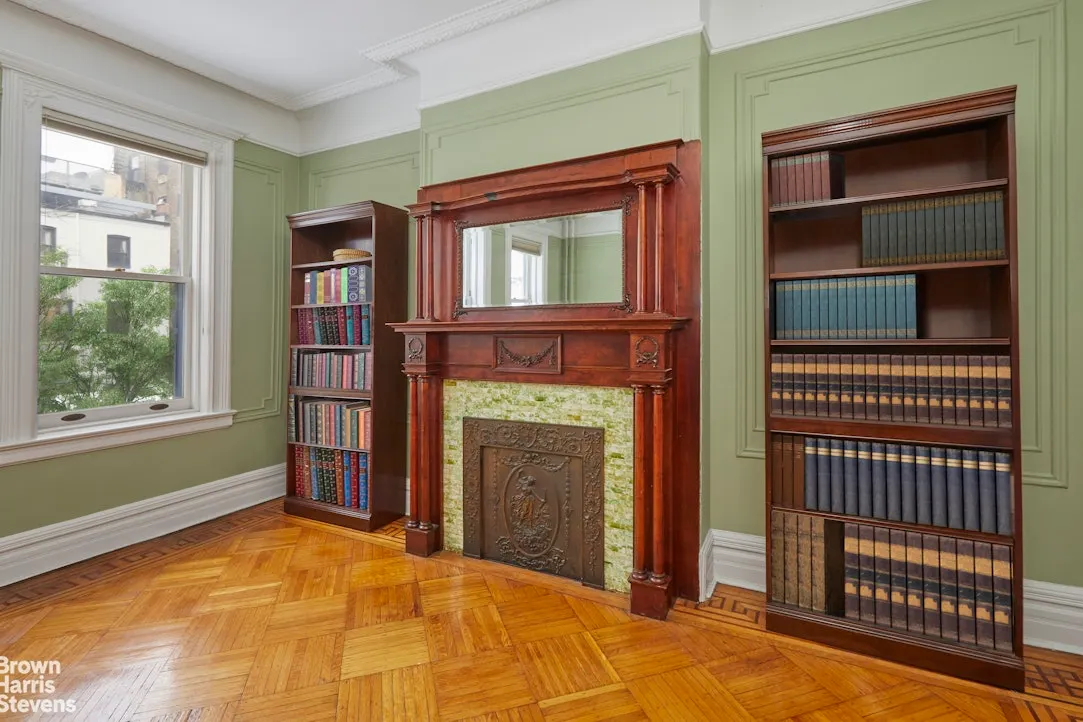 bedroom with mantel, wall moldings