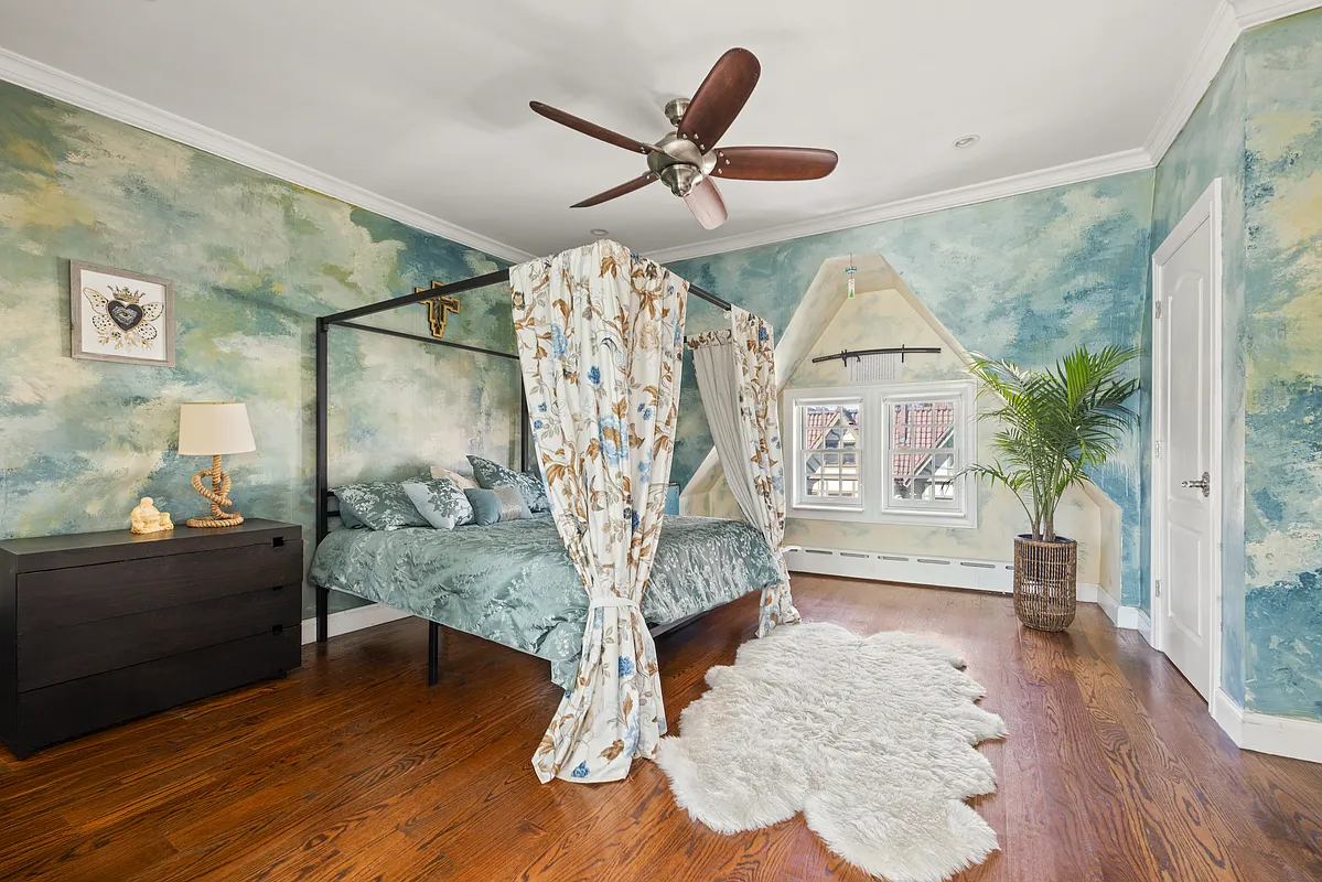 bedroom with blue swirled wallpaper, ceiling fan