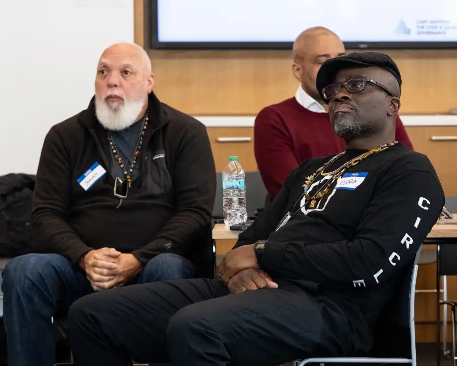 people with name tags sitting and listening to a speaker