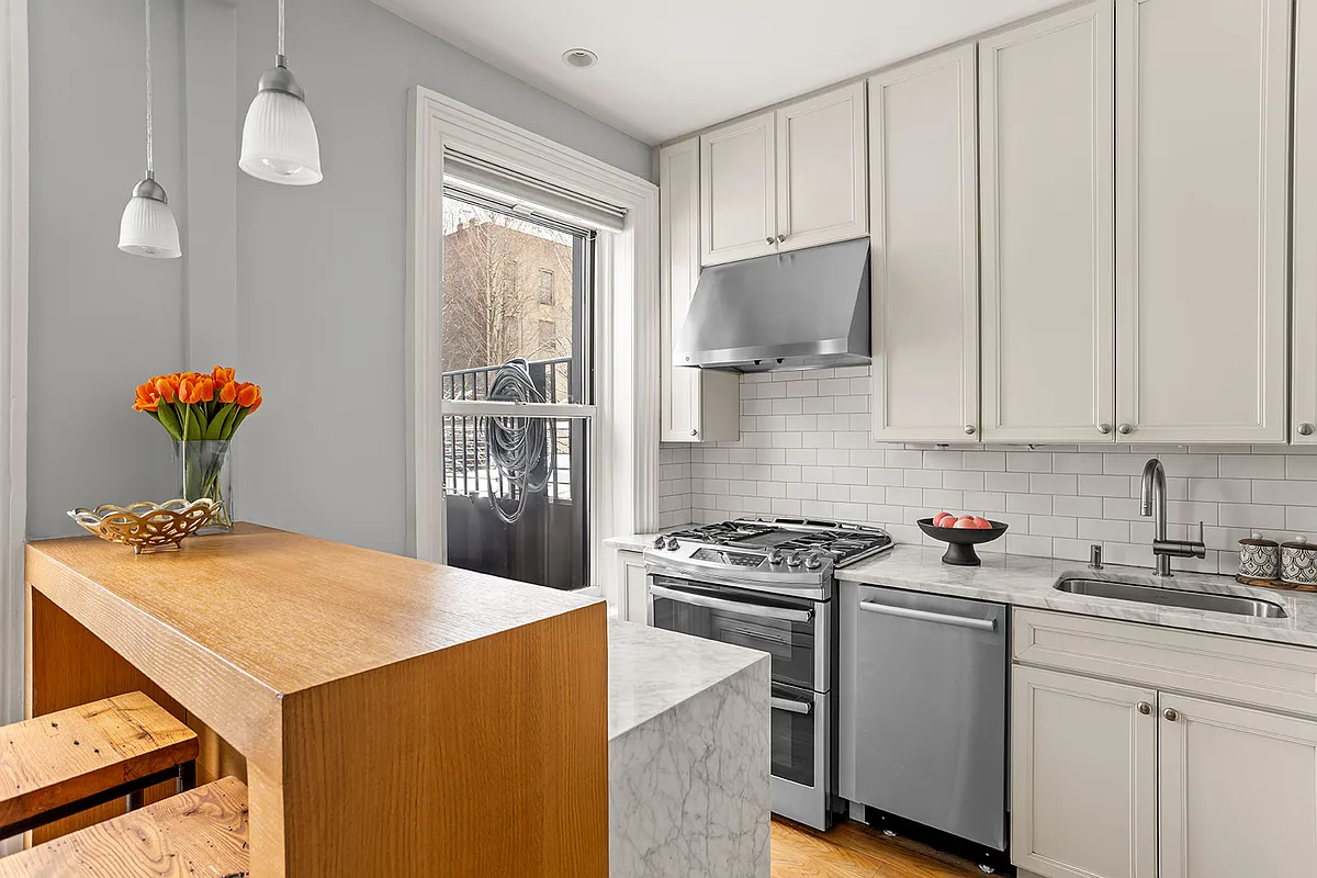kitchen with cream cabinets, stainless steel appliances, small peninsula