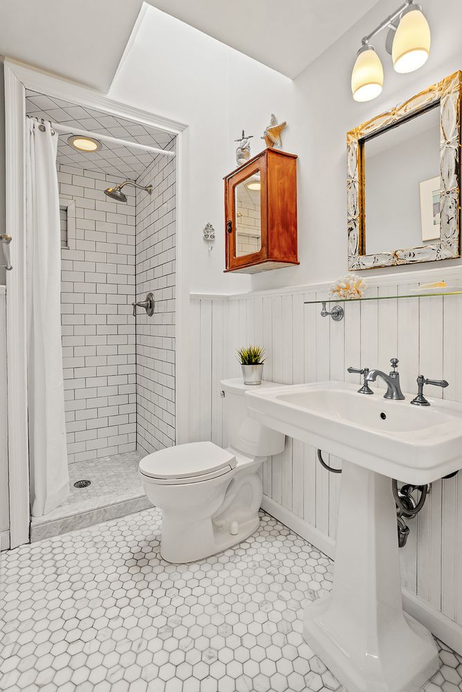 bathroom with walk-in shower, white fixtures