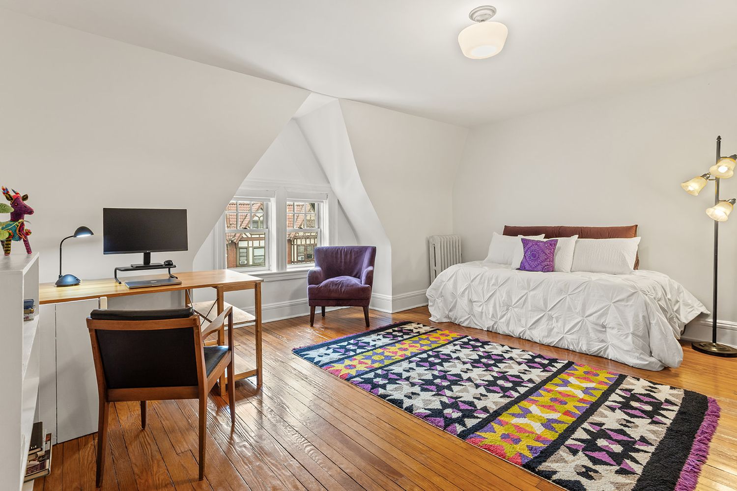 top floor bedroom with white walls, wood floor