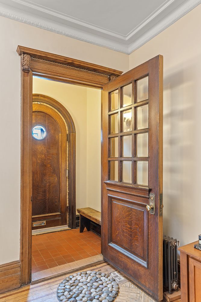 entry with wood door, terra cotta tiled vestibule