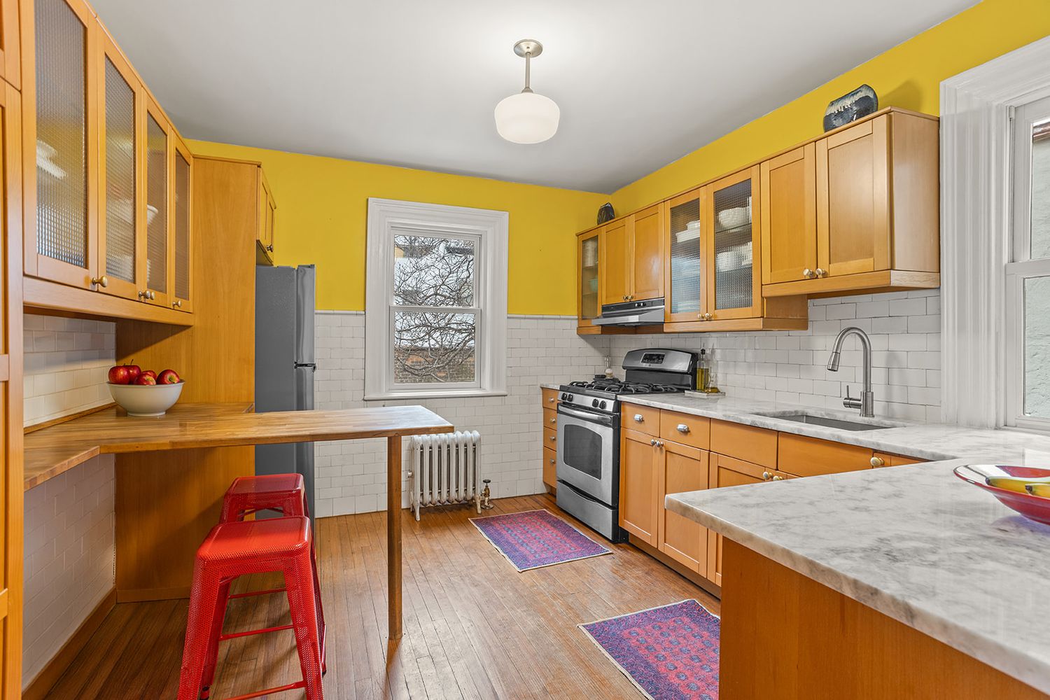 kitchen with wood floor, white subway tile backsplash, wood cabinets