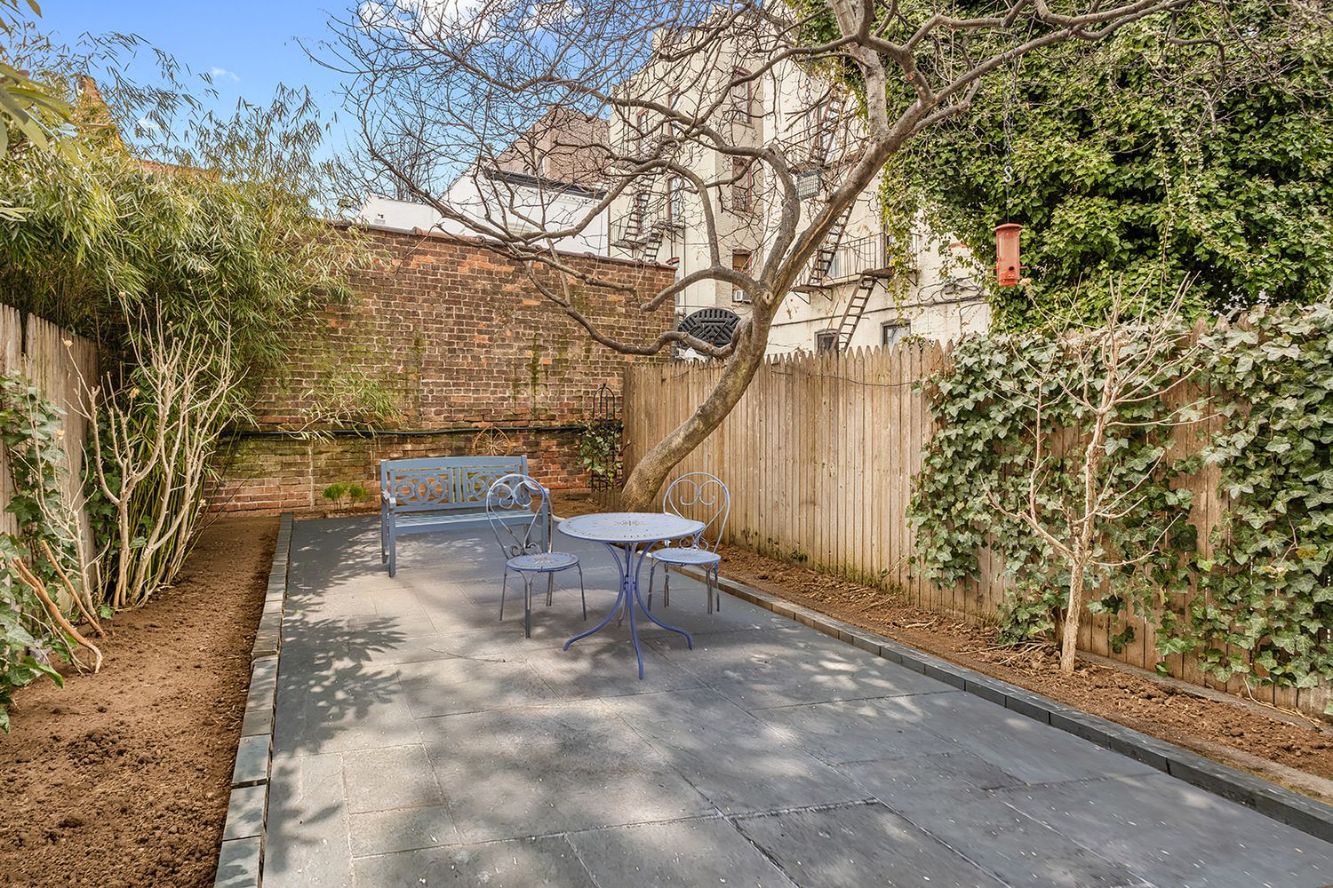 rear yard with paved patio, planting beds