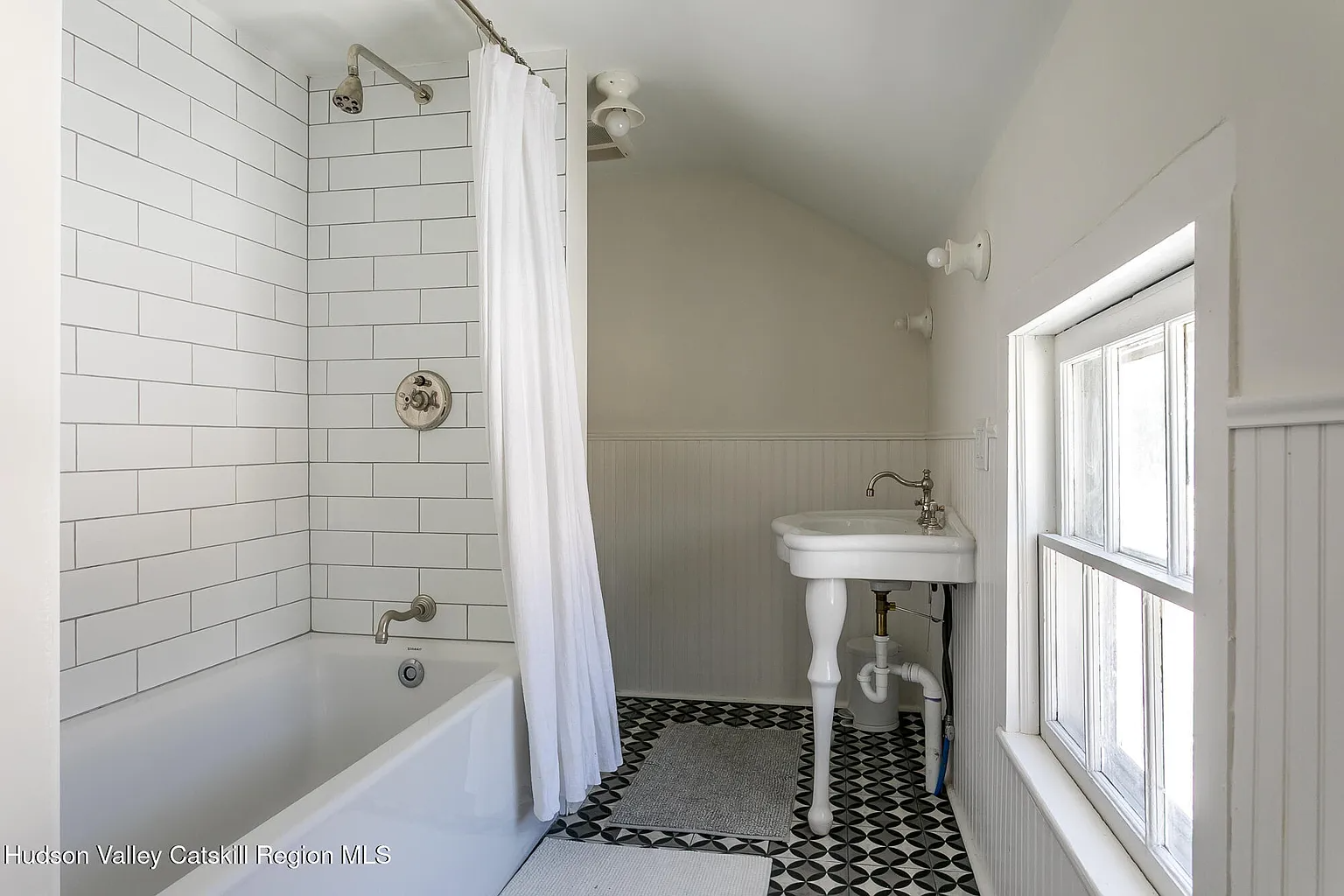 bathroom with graphic tile floor, console sink and beadboard