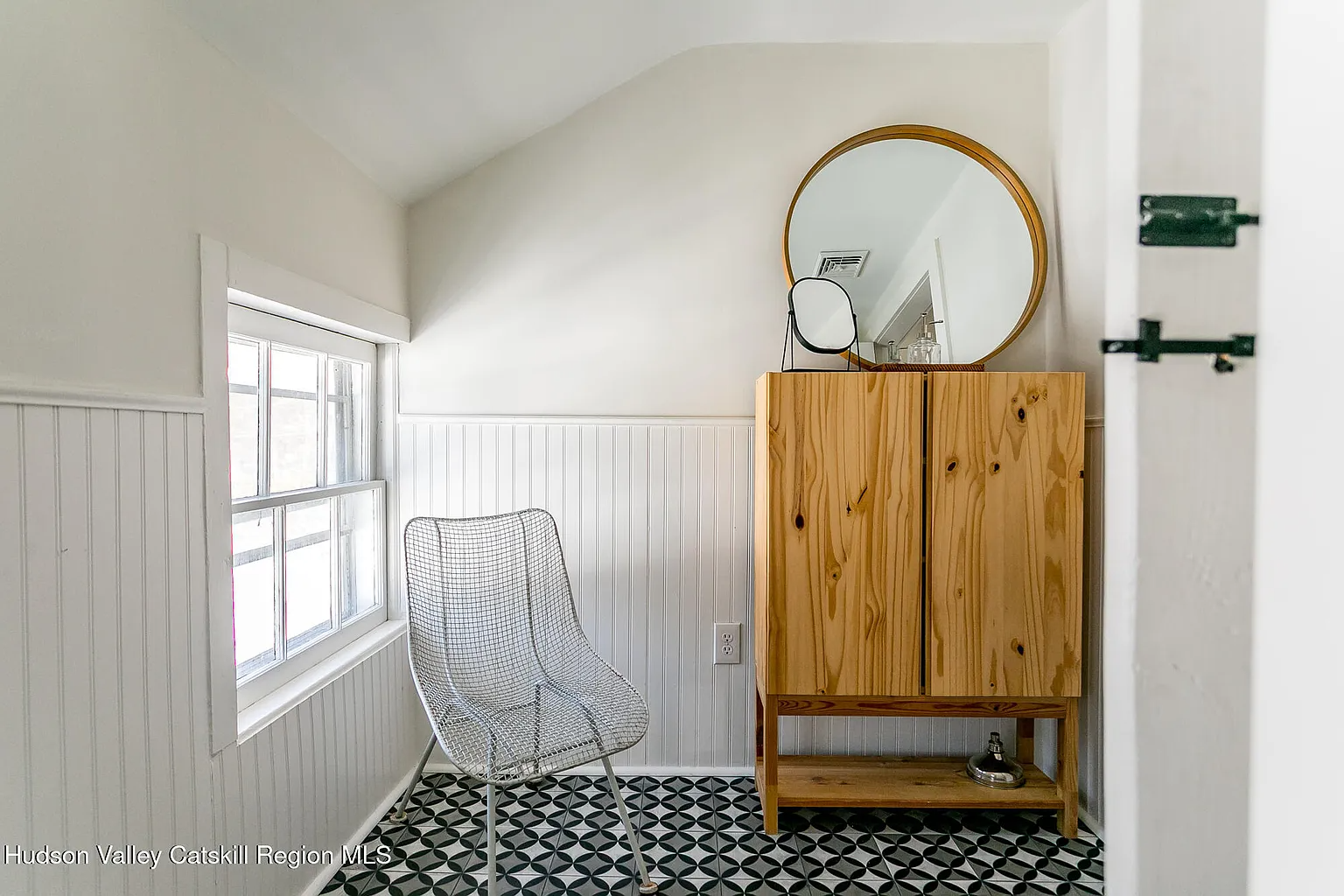 bathroom detail with beadboard and graphic tile floor