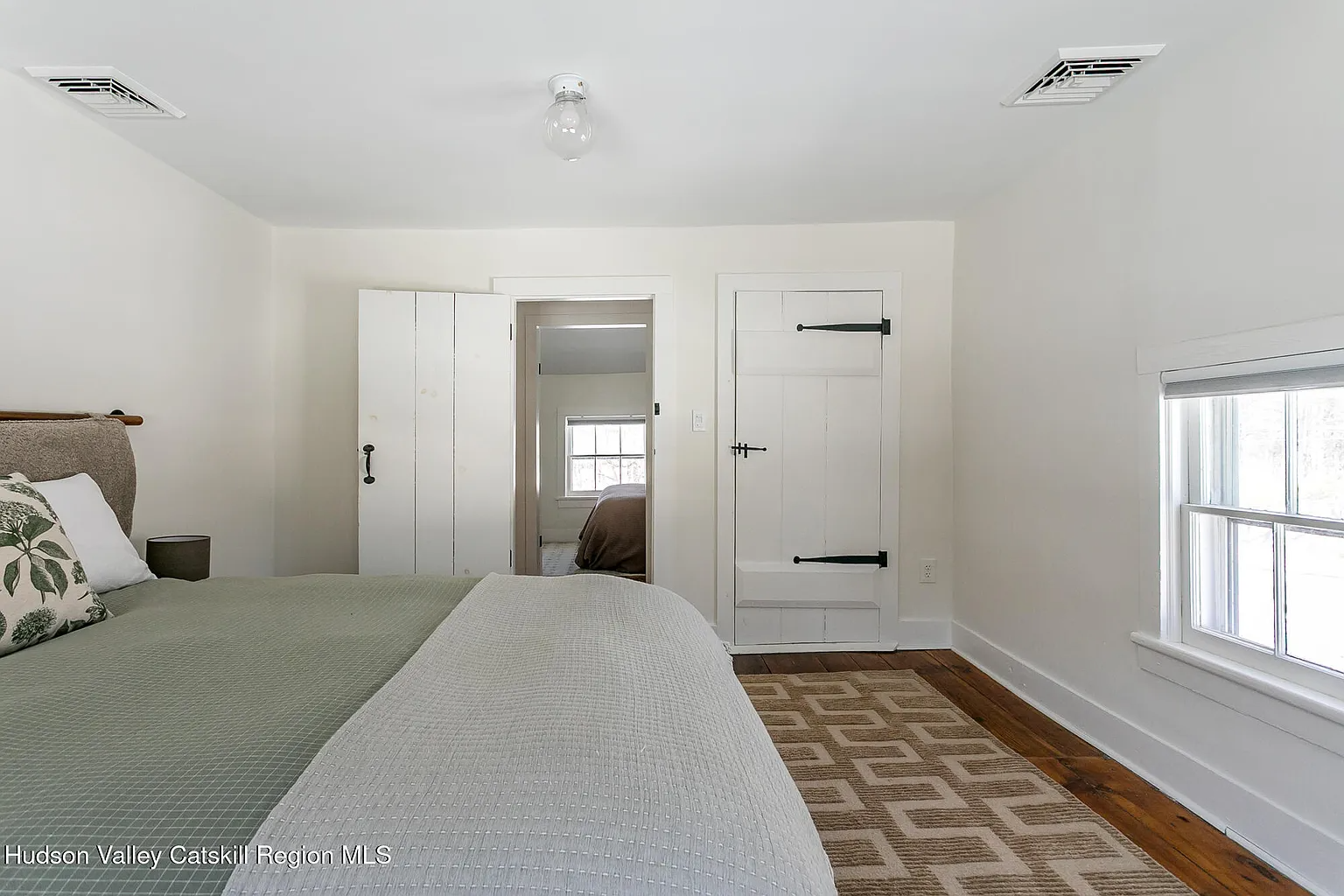 upstairs bedroom with angled ceiling, wood floor