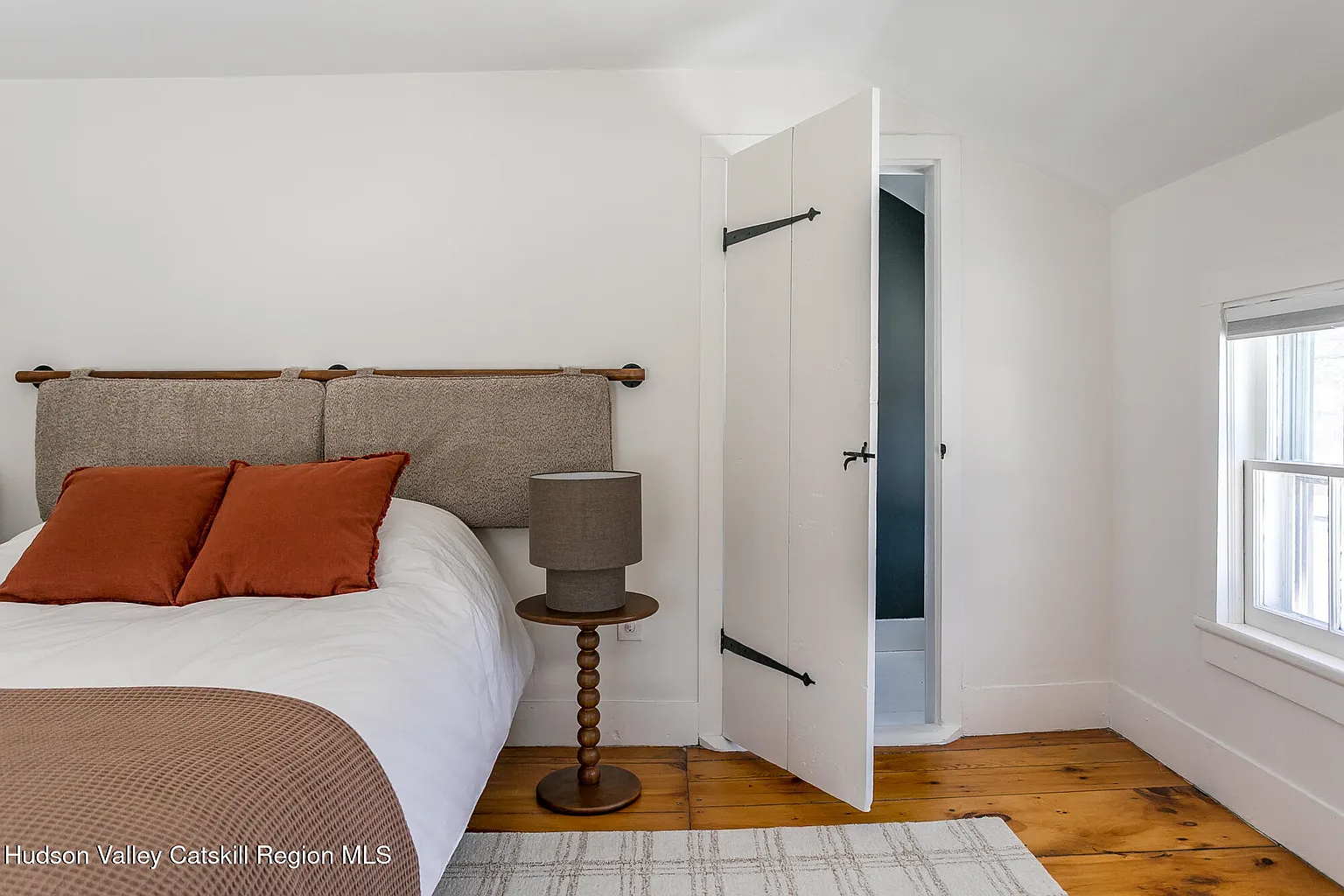 upstairs bedroom with angled ceiling, wood floor