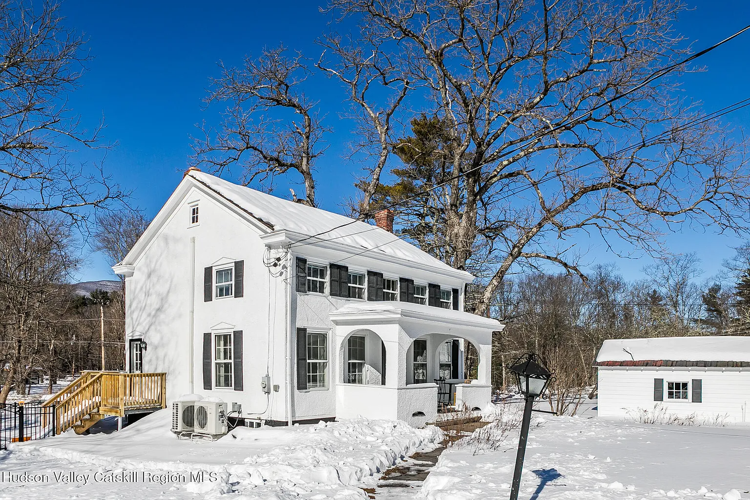 white stucco covered farmhouse with a porch