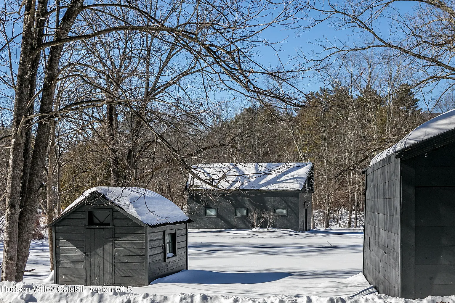 grounds showing three gray painted outbuildings