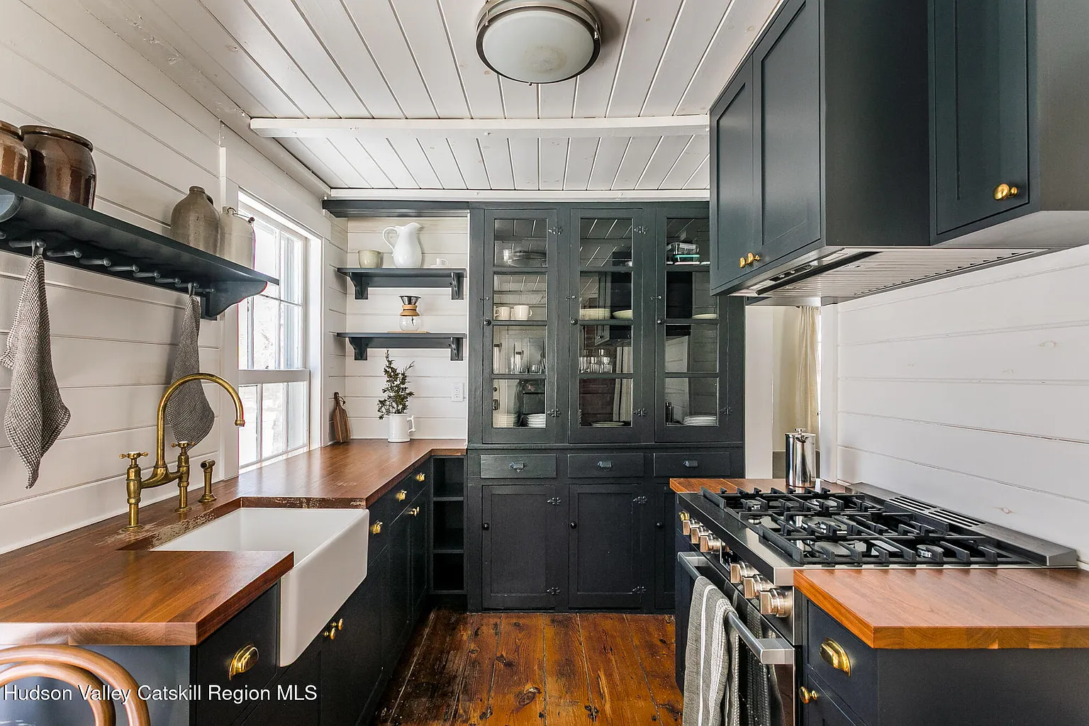 kitchen with dark blue cabinets, butcher block counters, apron sink