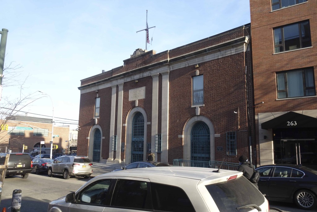 brick building with a sign above doorway for a public bath