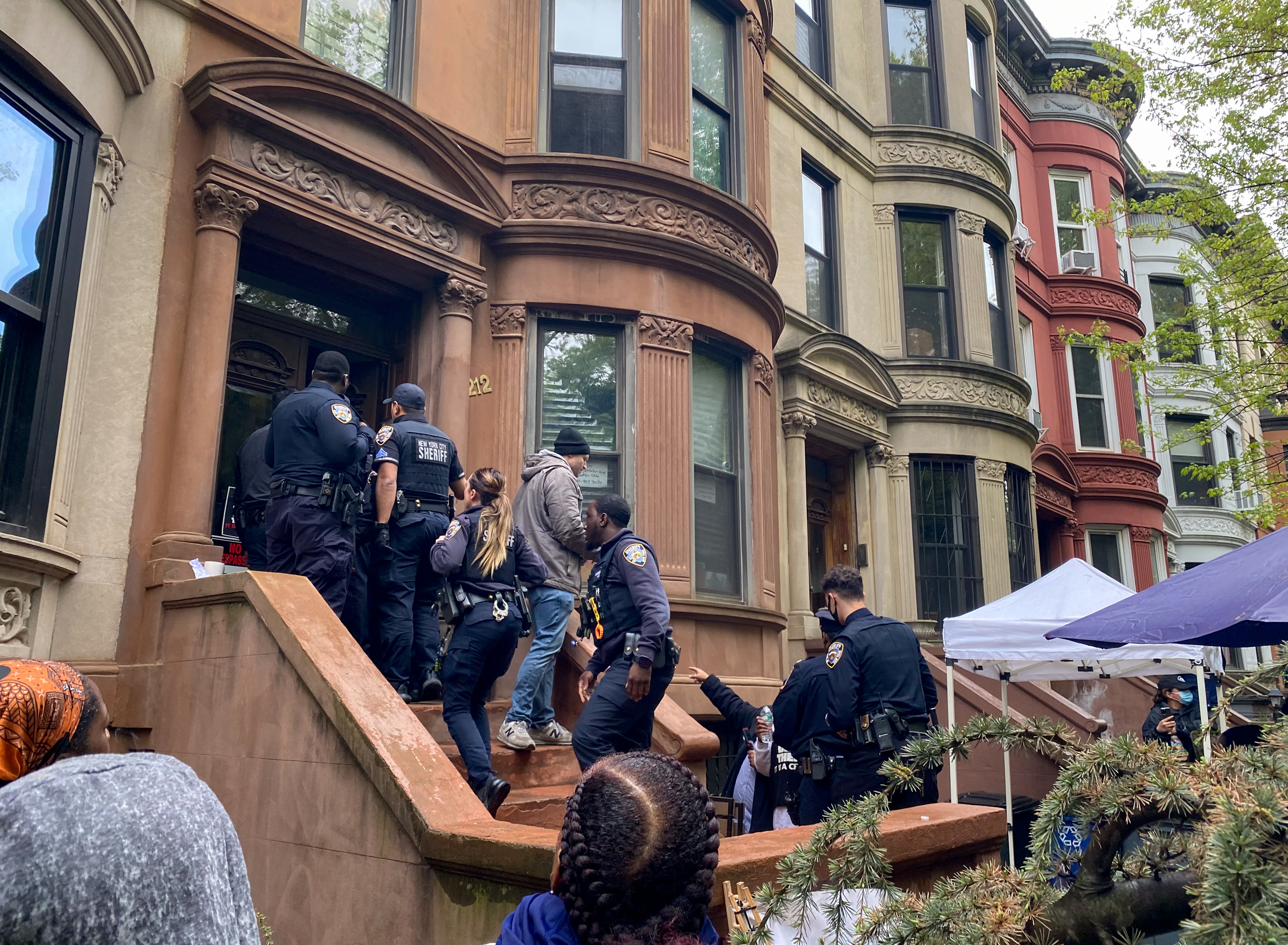 police on the stoop of a row house