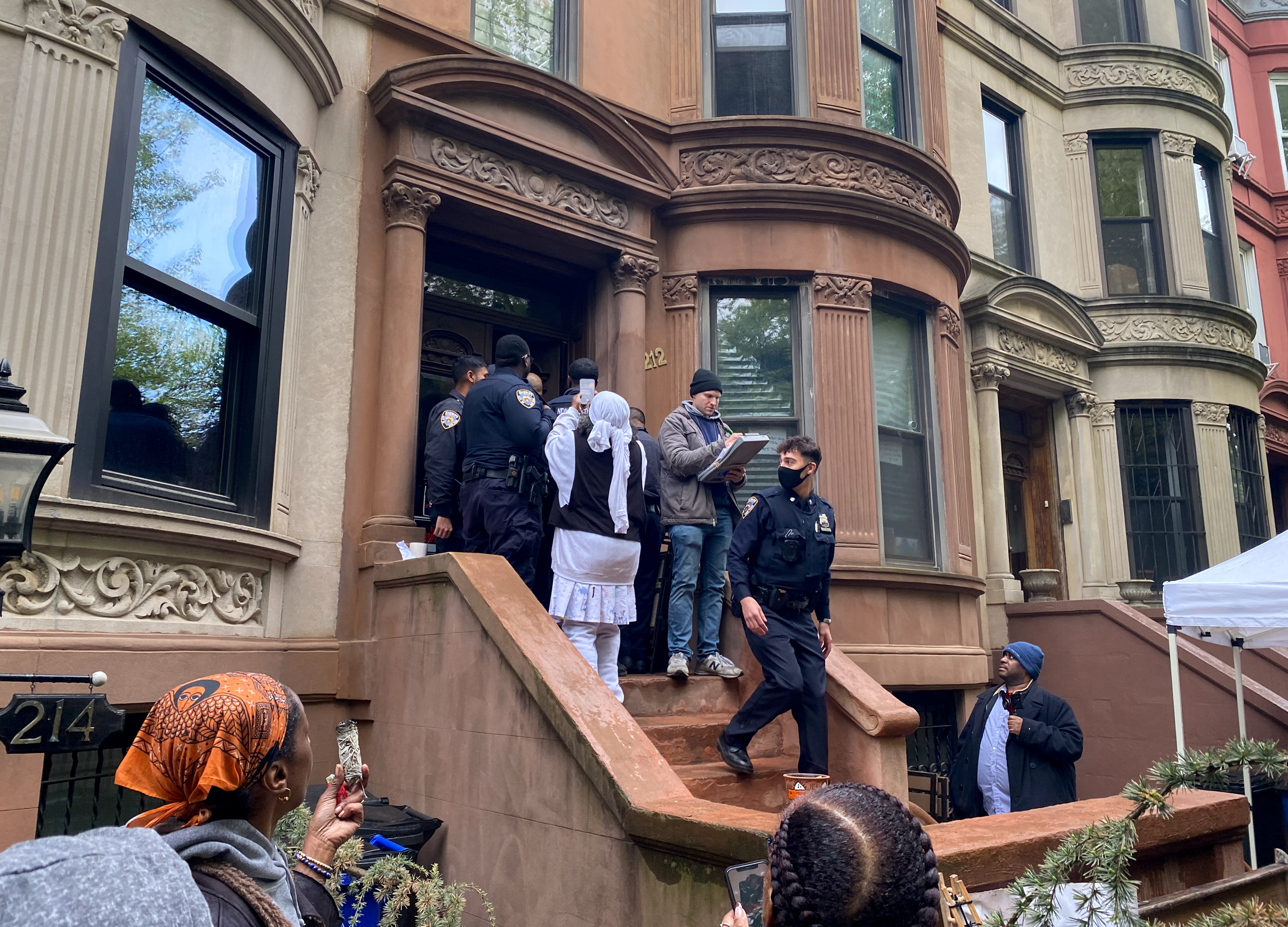 police on the stoop of a row house