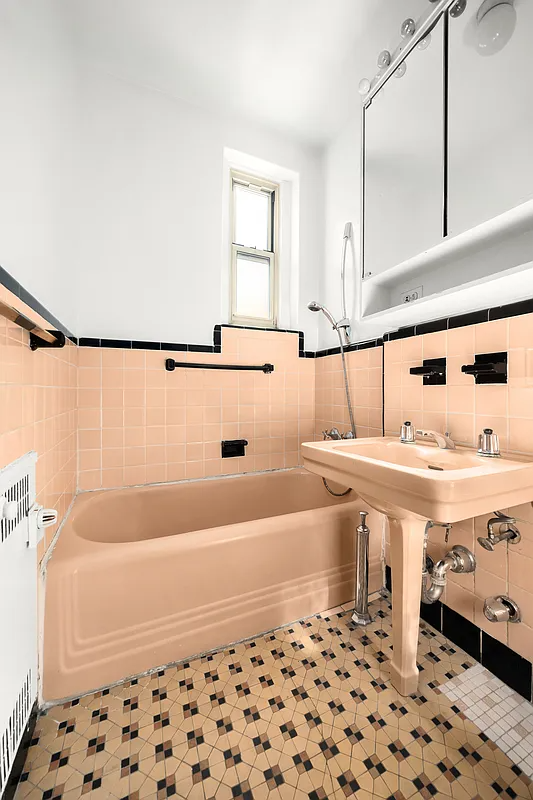 bathroom with peach tub and sink and wall tiles