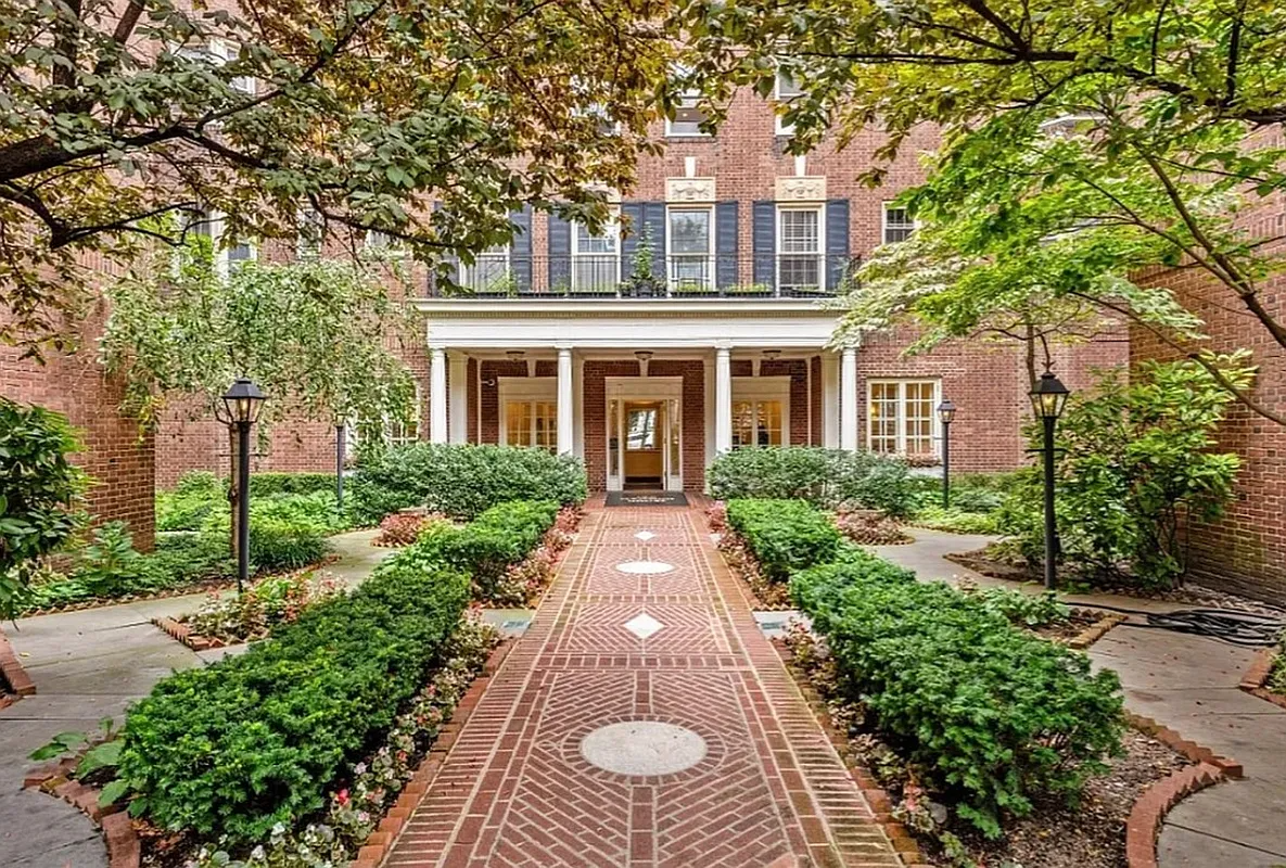 brick walkway through landscaped courtyard to brick apartment building