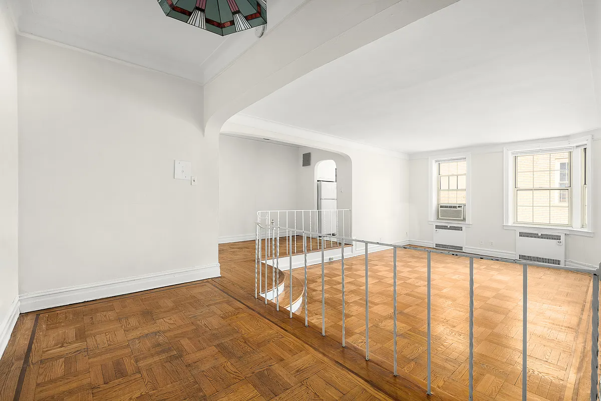 foyer with iron railing and view into sunken living room