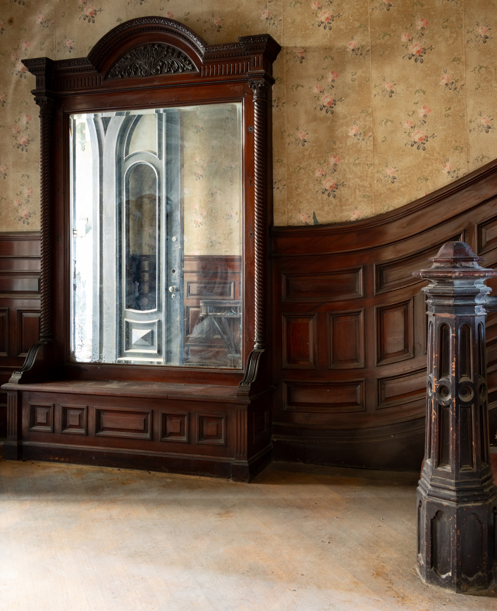 an entry hall in a brownstone with pier mirror and wainscoting