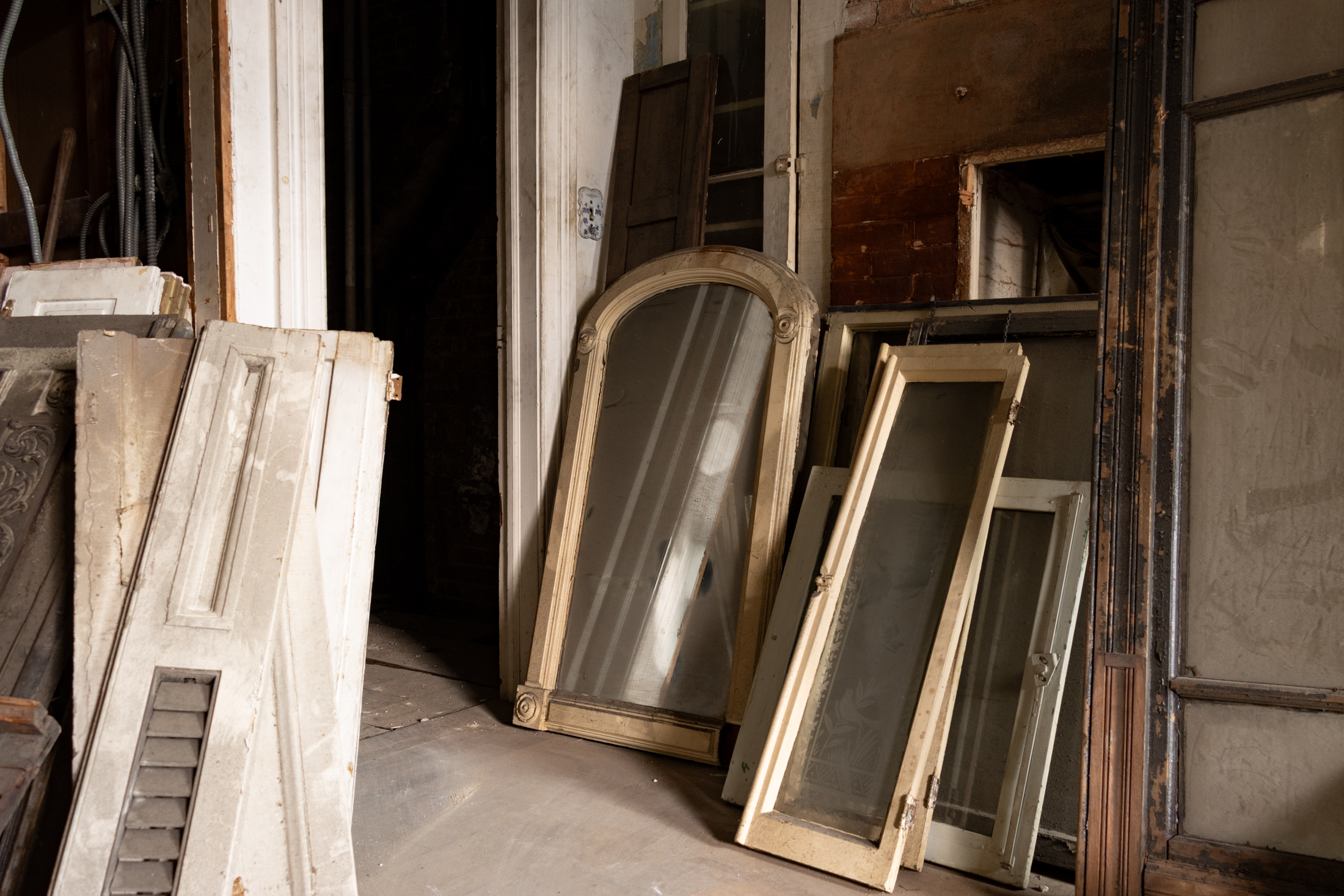 windows and shutters stacked in a basement