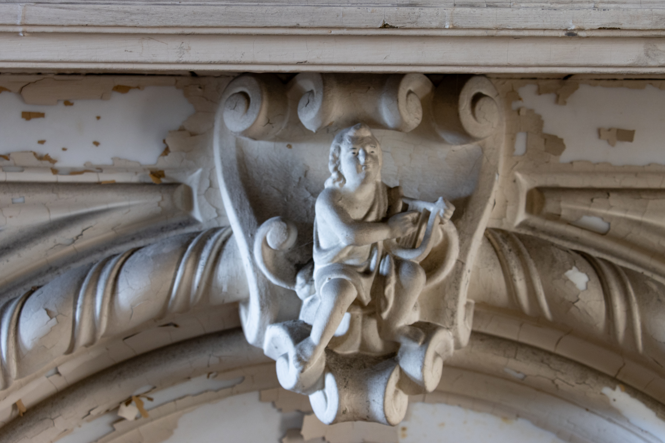 closeup of a mantel with a figure in the central panel