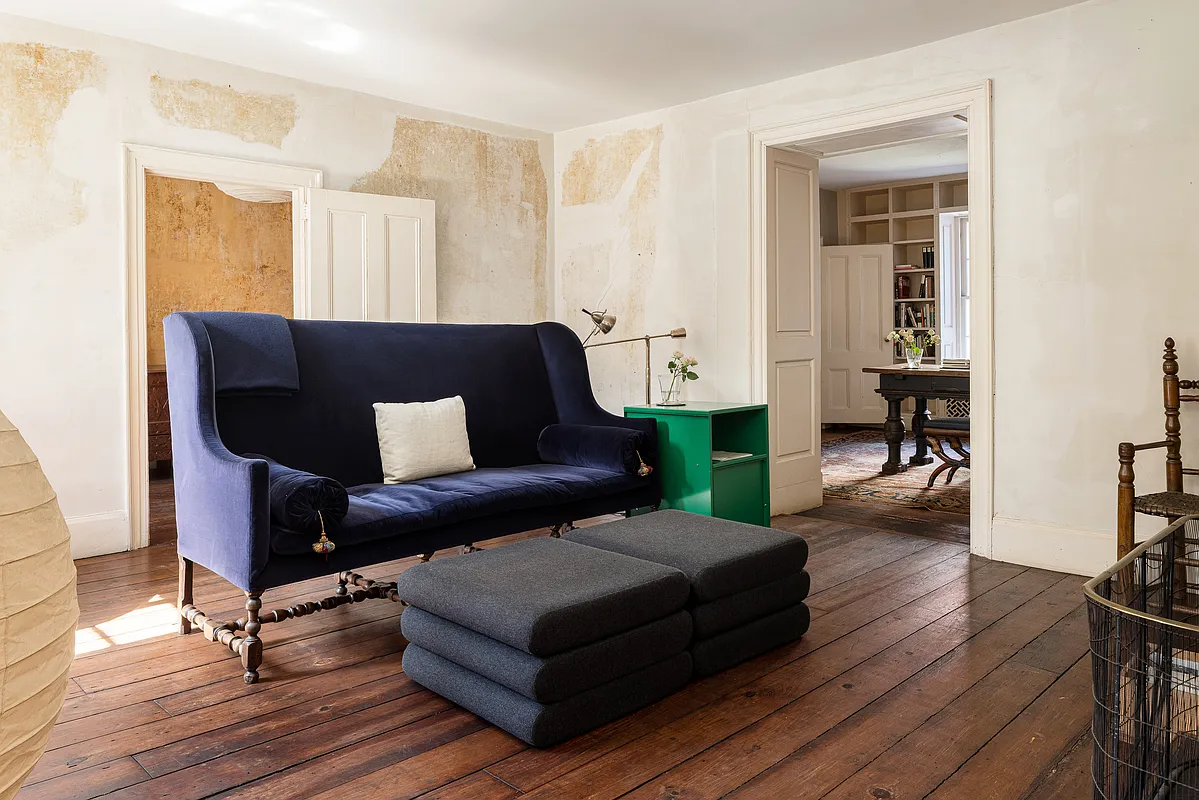 parlor with blue sofa on wood floor