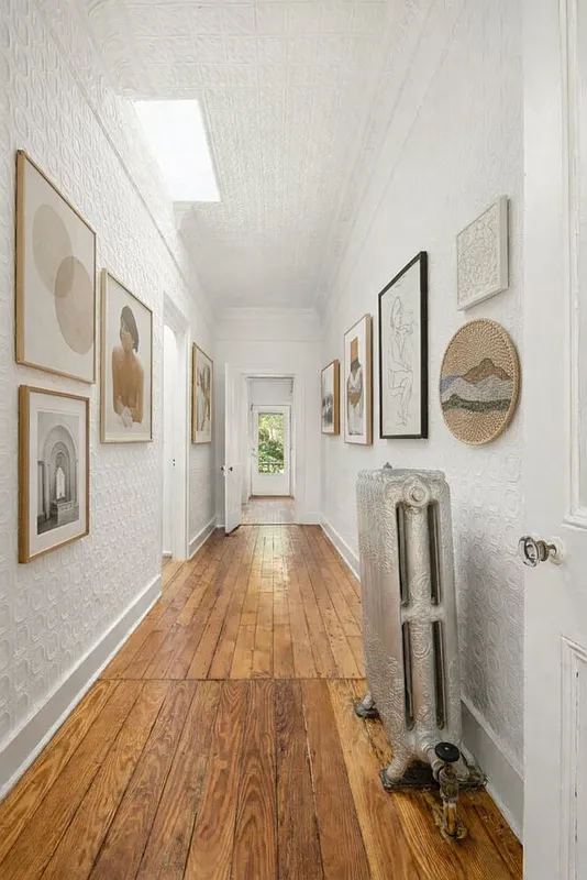 hallway with wood floor, skylight