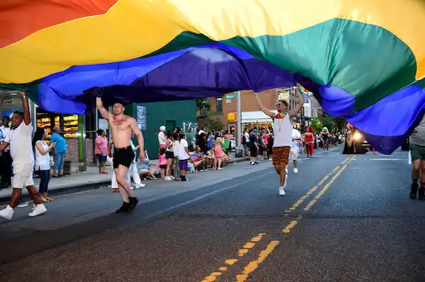 people running with a giant pride flag