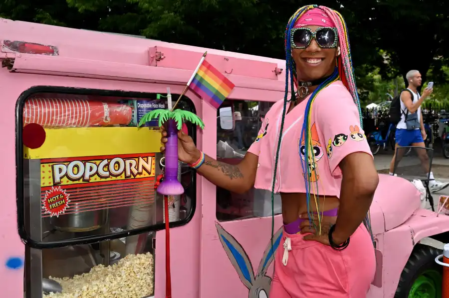 person posing by a pink popcorn truck