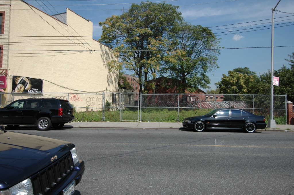 vacant site with parked cars in front