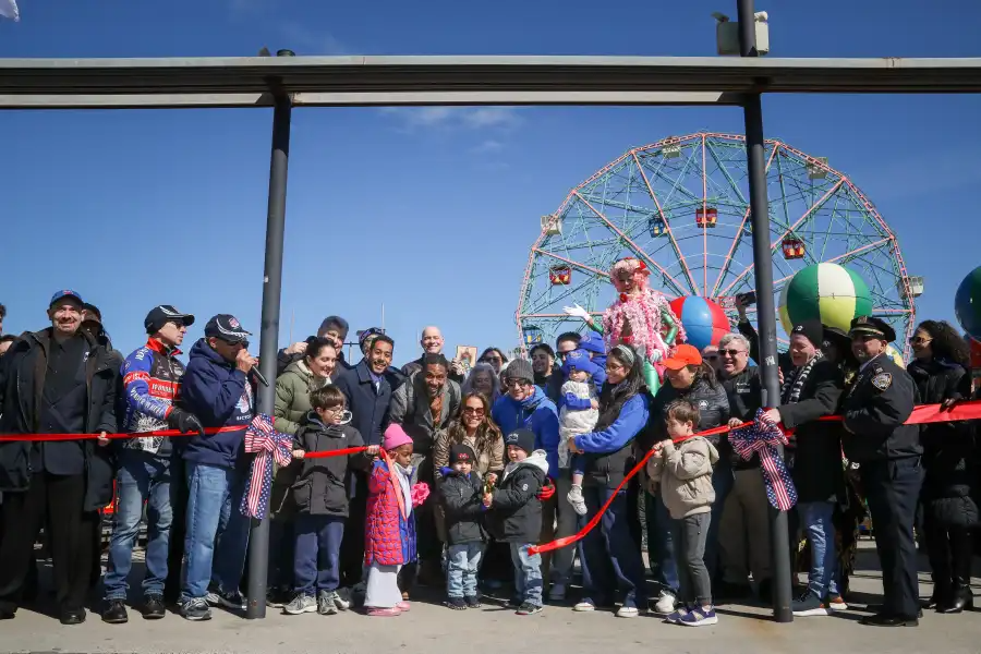 people cutting a red ribbon