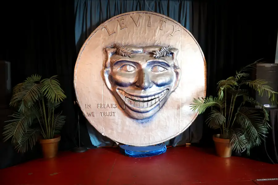 a fake, large penny with words in freaks we trust