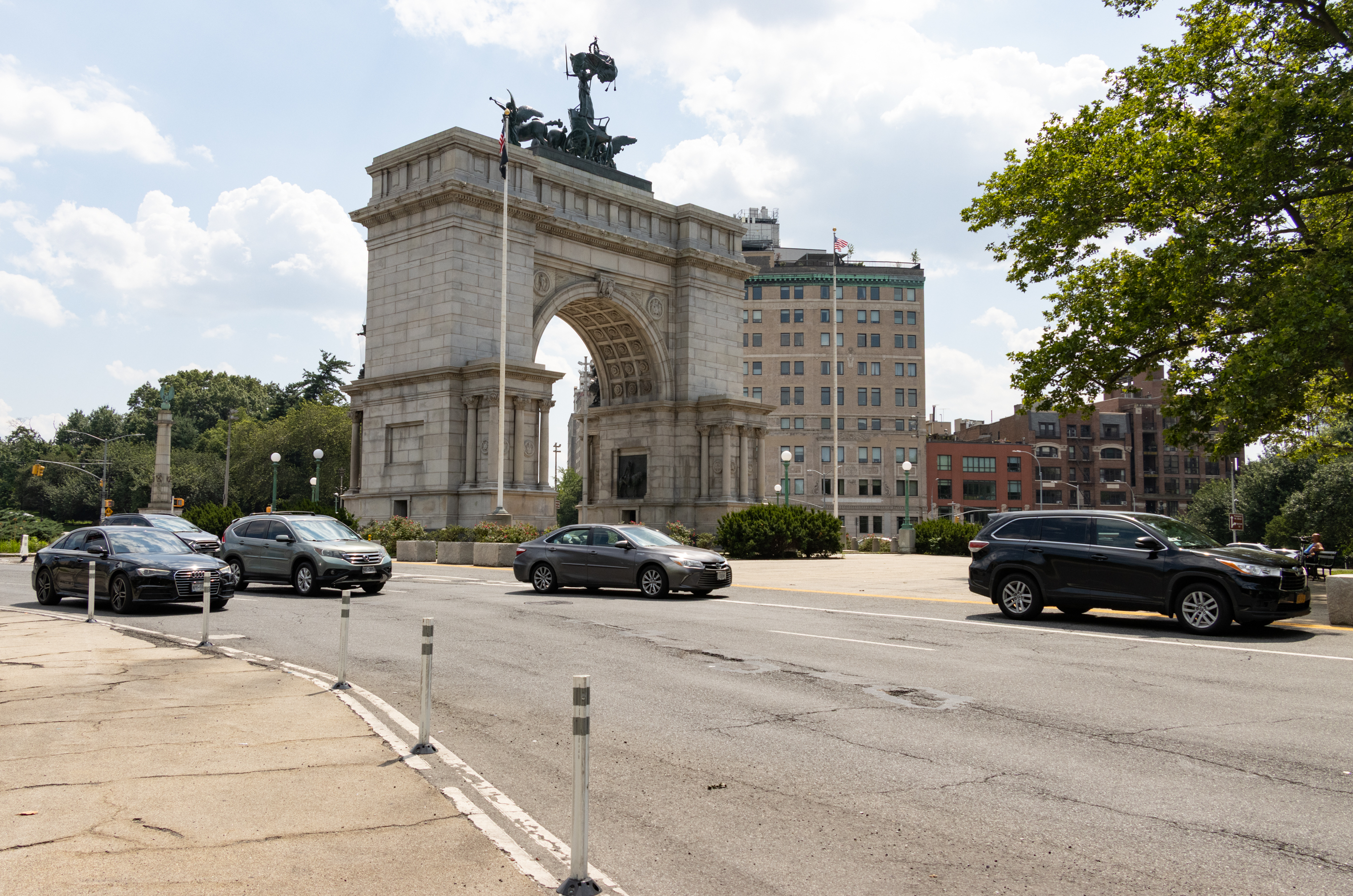 cars driving around the memorial arch