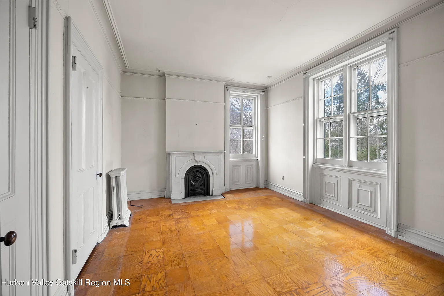 bedroom with marble mantel, wood floor