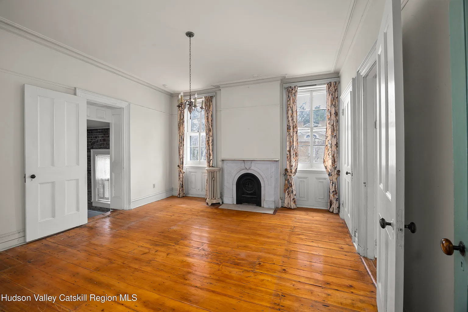 bedroom with marble mantel, wood floor