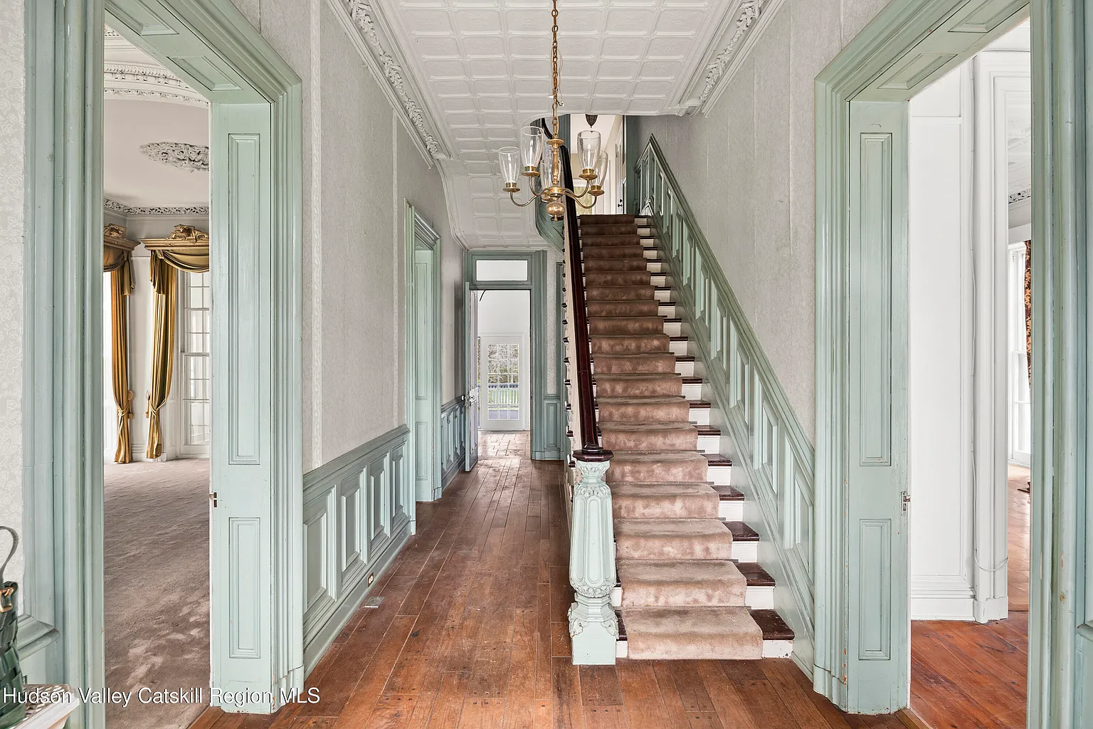 entry hall with wainscoting, tin ceiling, stair