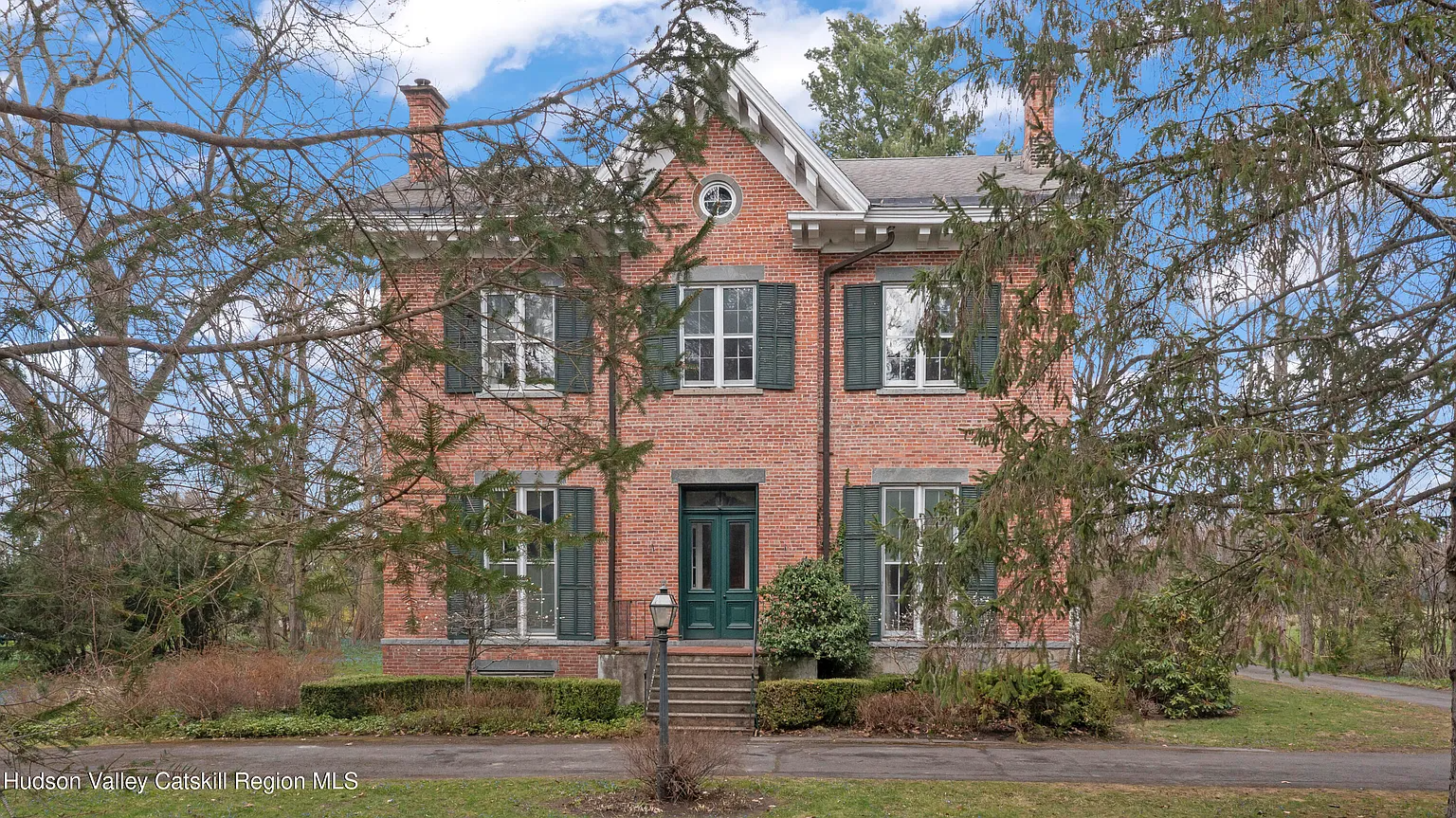 brick house glimpsed through trees