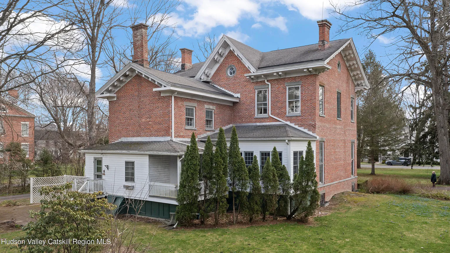 rear facade of brick house with sun room and porch