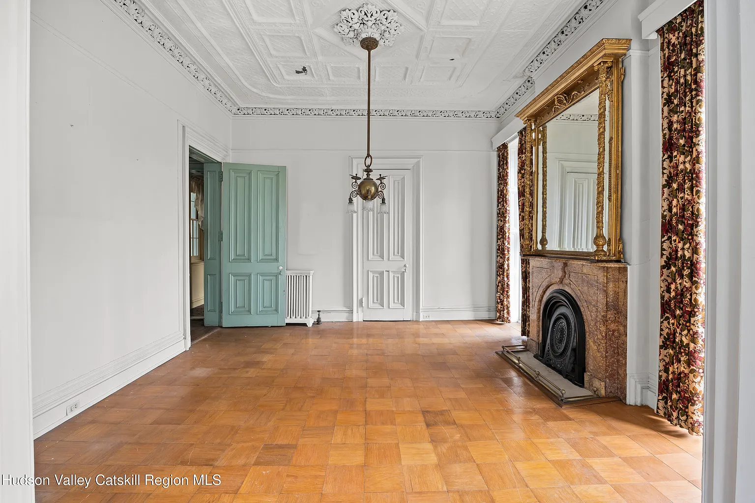 parlor with a marble mantel, tin ceiling, and ceiling medallion