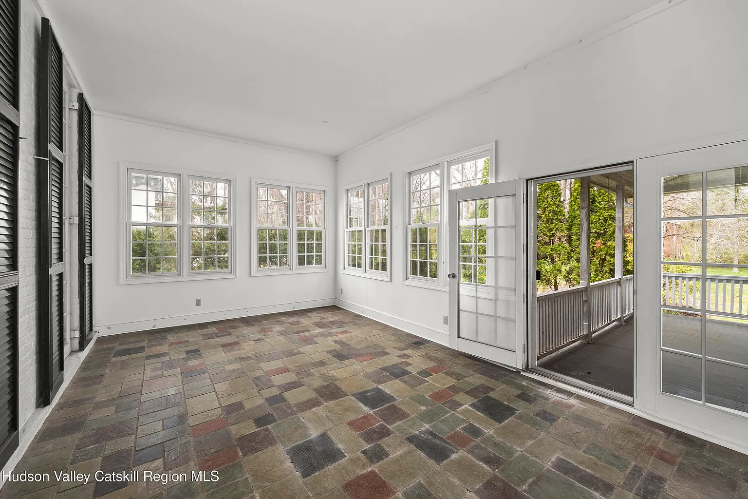 sunroom with stone floor, french doors to exterior porch