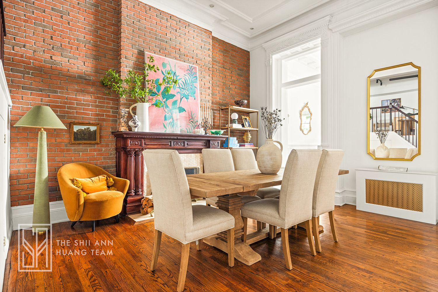 dining area with wall of exposed brick, wood mantel