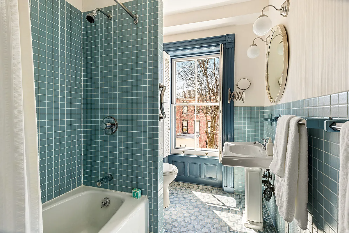 bathroom with baby blue wall tile, white fixtures