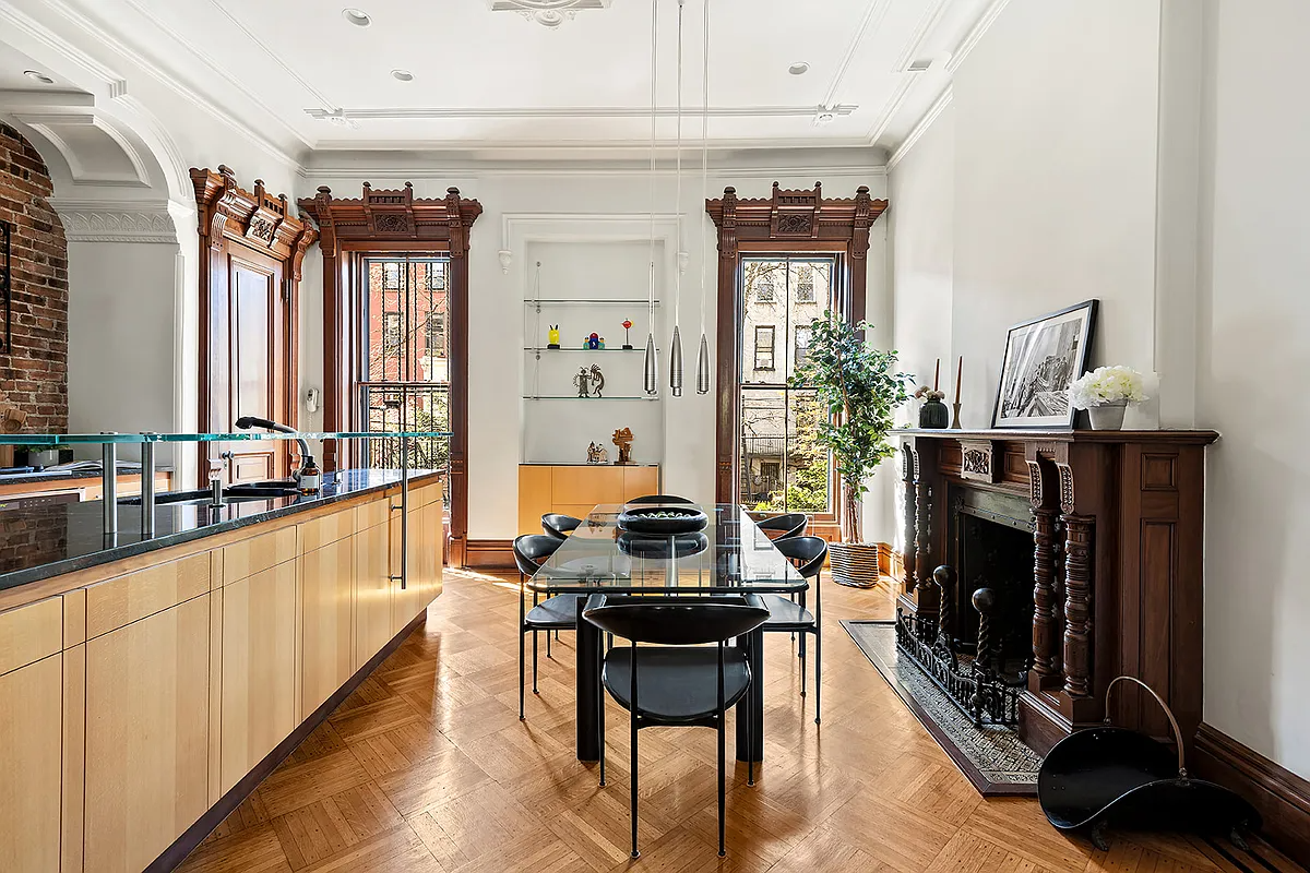 kitchen with modern pale wood cabinets and a period fireplace