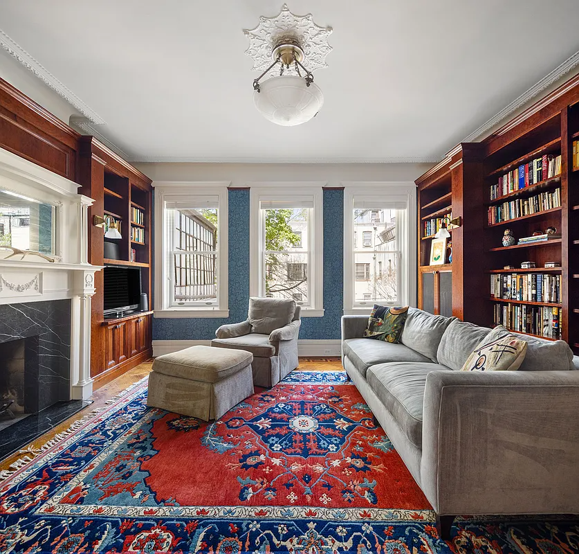 bedroom set up as a library with bookshelves, mantel