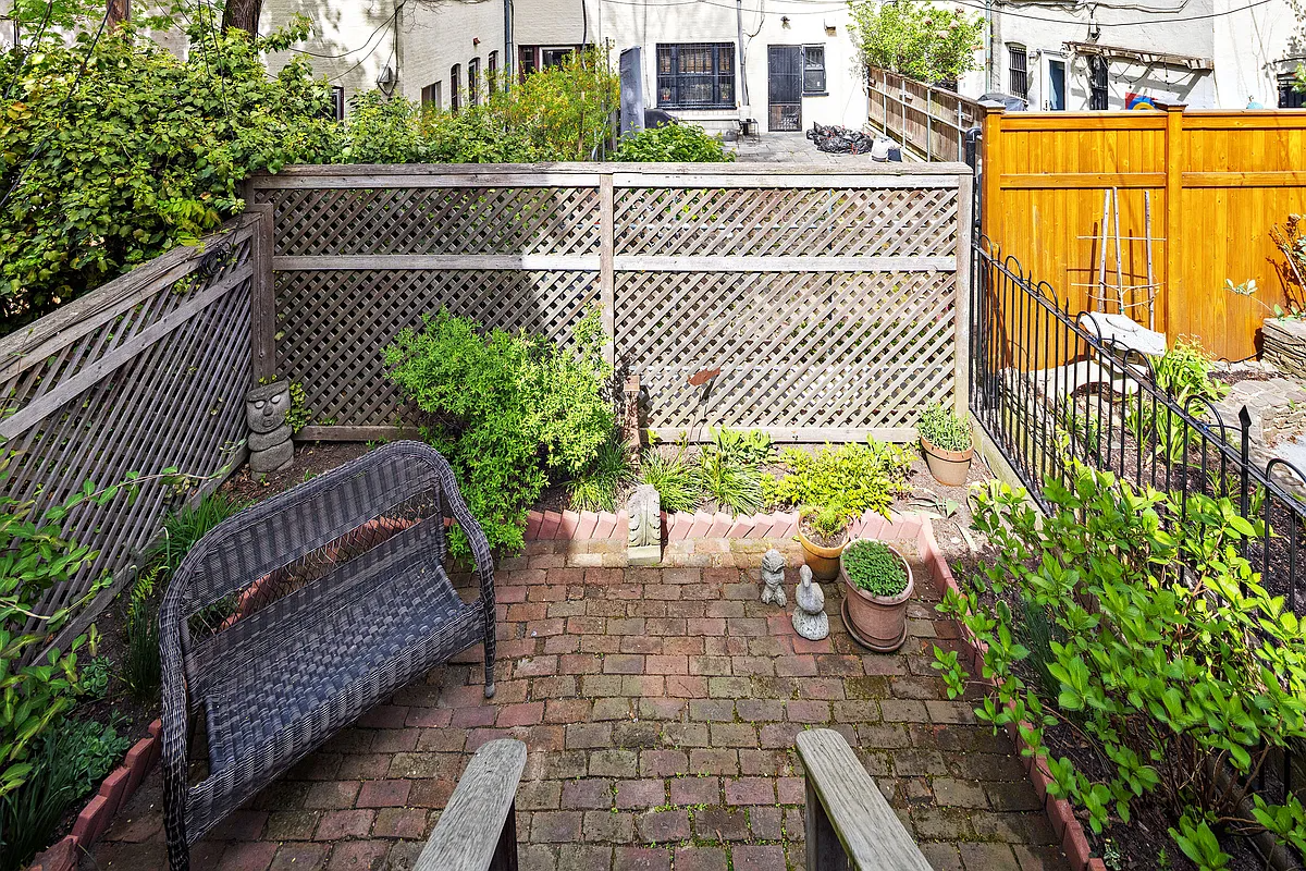 rear yard with brick patio, planting beds