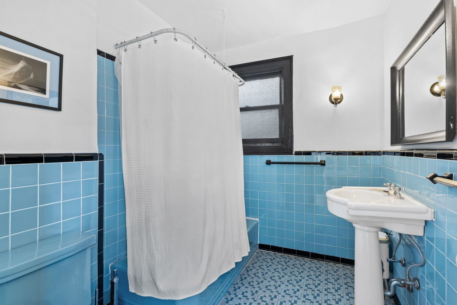 bathroom with blue tub, toilet and tile