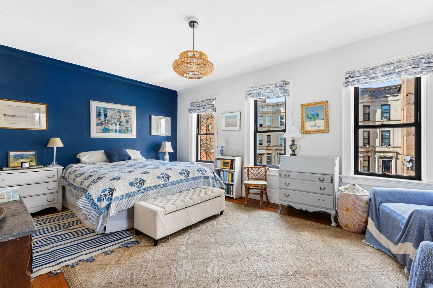 bedroom with one blue wall, wood floor